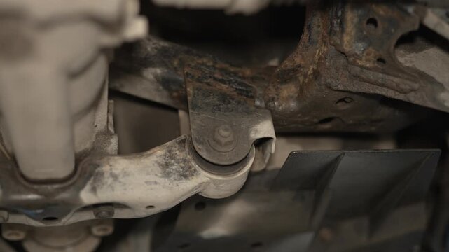 A close-up view of rusty car suspension and undercarriage parts.