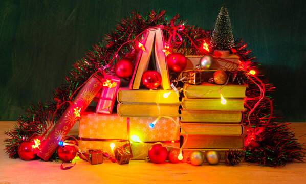 giving books for christmas,christmas  gift,present,reading,literature,education, christmas,holiday concept with heap of books, christmas lights and decoration