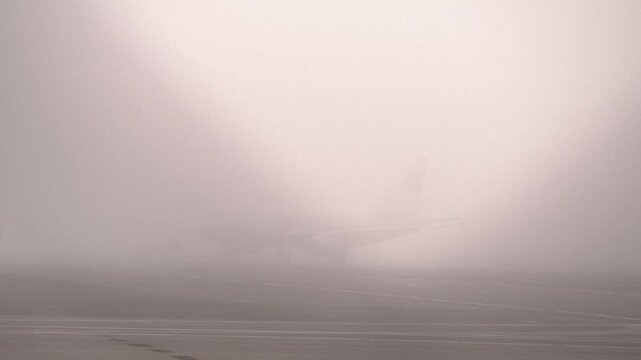 Challenging low visibility weather conditions for aircraft to operate in. The aircraft is on the tarmact waiting to push back.