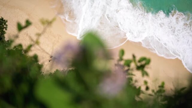 Ocean waves washing over a sandy beach in Nusa Penida