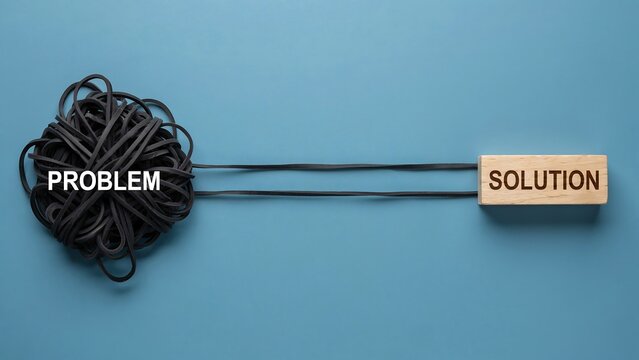 Minimalist conceptual image showing black tangled elastic bands labeled problem connected by two straight lines to wooden block labeled solution over blue background flat lay top view.