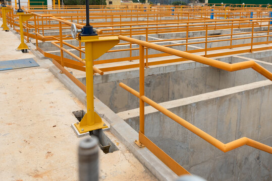 General view of settling basins and walkways with yellow handrails at water treatment facility