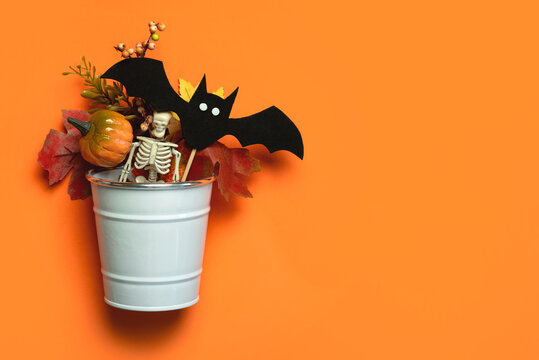 Top view of white metal cube with pumpkins,autumn leaves,Halloween bat and space for text. Halloween concept background
