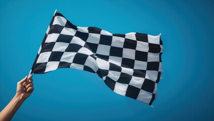 Obraz premium Hand signaling with a checkered flag against a blue backdrop.