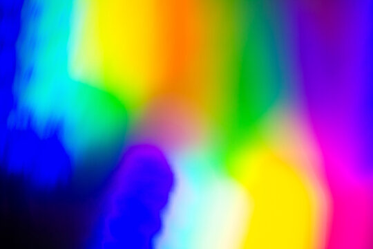 De focused abstract vibrant iridescent holographic rainbow foil background with light leaks. Glitter surface. Abstract blurred rainbow background.