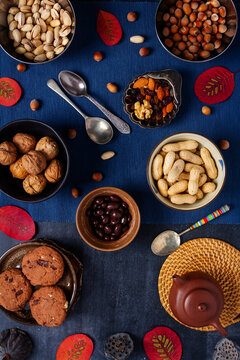Food themed still life with crockery, various nuts and tea. Flat lay. Top view.
