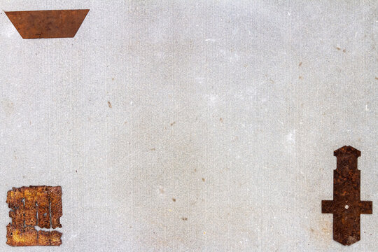 A group of various old rusty bits and pieces arranged on a concrete surface. Old rusty nuts, bolts, nails and other parts flay lay on gray background.