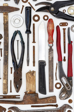 Flat lay of old hand tools on white background. Large collection of various rusty tools and bits arranged on white.