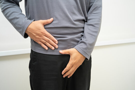 Hernia, Asian man stomach ache, abdominal pain and urology problem health.