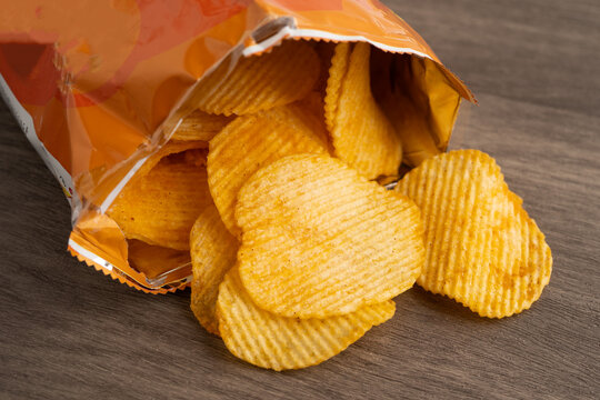Potato chips, delicious BBQ seasoning spicy for crips, thin slice deep fried snack fast food in open bag.