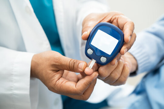 Doctor check diabetes from finger blood sugar level with finger lancet.