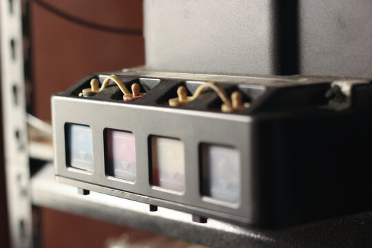 close-up view of an ink tank system attached to an inkjet printer showing visible cyan, magenta, yellow, and black levels.