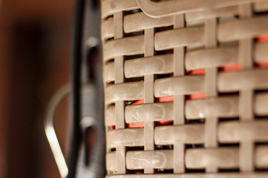 macro shot of a brown plastic woven storage basket texture showing an inner red object through the gaps.