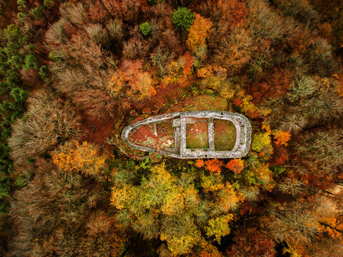 An old fort ruins of Alt Wartburg among the colorful autumn forest trees by drone aerial photography