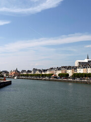 Obraz premium View of the historic harbor and traditional buildings in Trouville-sur-Mer, France, along the canal on a sunny day.