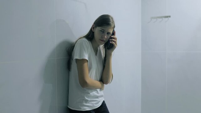 Worried generation z teenager using smartphone calling indoors.