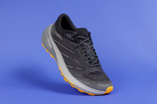 Trail Running Shoe on Blue Background, Athletic Sneaker Product Shot