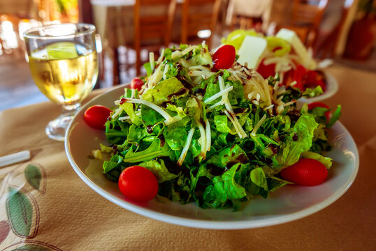 Greek salad with white wine in a traditional restaurant