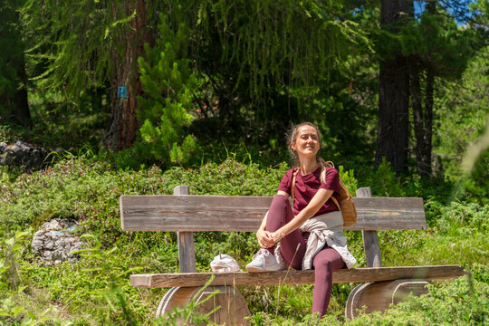 Female hiker relaxing on wooden bench after mountain hike