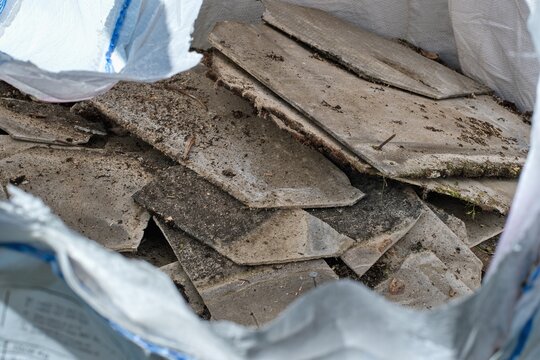 Building  material with asbestos fibres collected in asbestos disposal bag. Health harmful and hazards effects.