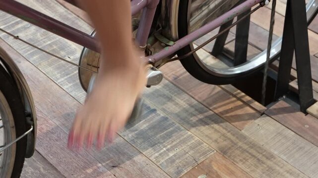 Close-up of female barefoot pedaling stationary bicycle generating electricity