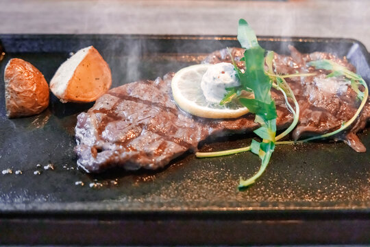 熱々の鉄板で香ばしく焼かれたステーキとポテト