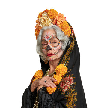 Senior woman with grey hair and traditional Day of the Dead sugar skull makeup wearing a black floral shawl against isolated on transparent or white background, png