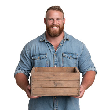 Smiling muscular bearded man in a denim shirt holding an empty wooden crate against isolated on transparent or white background, png