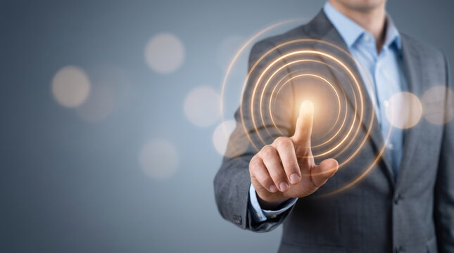 Businessman touching glowing amber light rings on a dark blue background offering copy space for digital innovation and fintech campaigns.