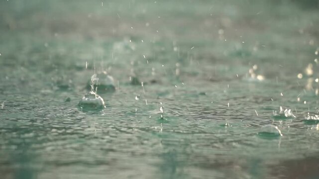 Raindrops Falling on Water Surface with Ripples and Soft Light