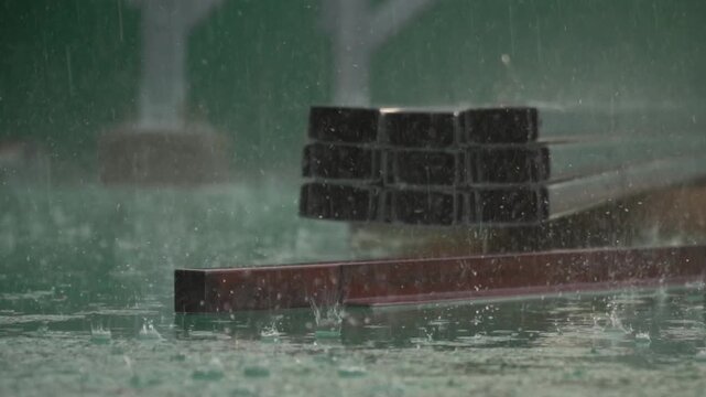 Heavy Rain Falling on Metal Construction Materials with Splashes on Green Surface