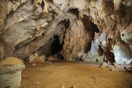 Wide interior landscape of an underground cave system with natural stone arches and rock chambers