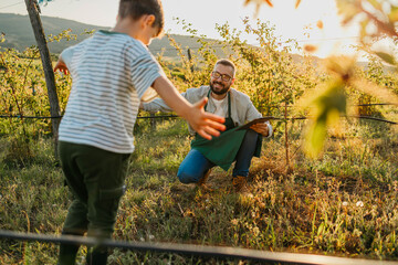 Naklejka premium Dad and son hugging in the orchard