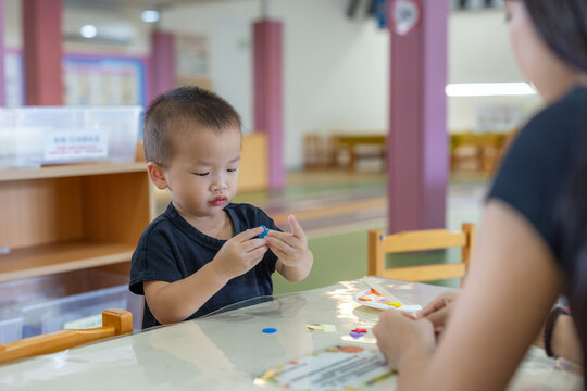 Little boy playing with toys in kindergarten