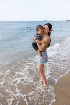 Mother holding crying boy on the  beach