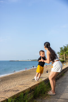 Mother hold her son by the beach