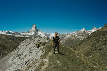 Fototapeta premium Hiker enjoying breathtaking zermatt mountain landscape under clear blue sky