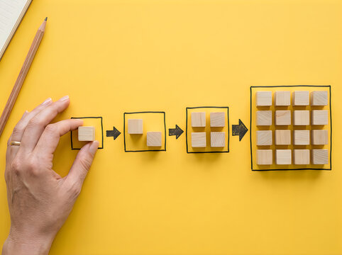 Hand placing wooden cube for exponential growth. Business strategy for scaling and success.