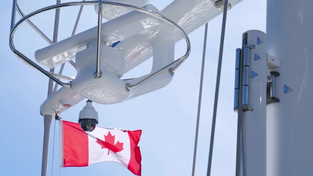 Modern yacht radar mast with security dome camera and Canadian flag