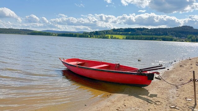 Red fishing boat on the shore of Lake Lipno in the Czech Republic