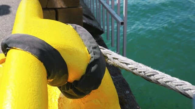Heavy duty marine mooring rope with black chafing guard on yellow rail