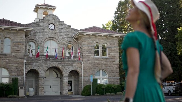 A senior woman enjoys a sunny day as she walks near City Hall in Sonoma California with a smile on her face.