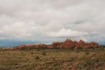 Clouds drift above rock formations near the Devils Garden Trail at Arches National Park, Utah © LB Photo Co