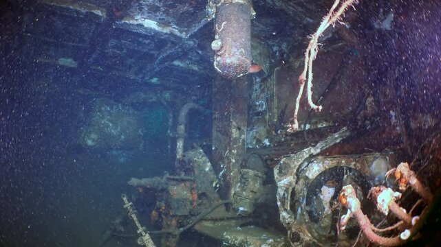 Plunge into the silent realm of a deep-sea shipwreck in the Sea of Japan. Glimpse inside its cavernous hull, where encrusted engines and spectral pipes reside, a profound aquatic monument.