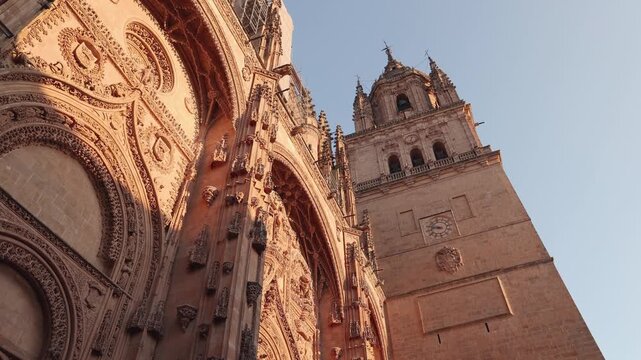 Ornate gothic facade and bell tower of the New Cathedral of Salamanca, Spain, bathed in the warm light of the golden hour, showcasing its intricate plateresque carvings