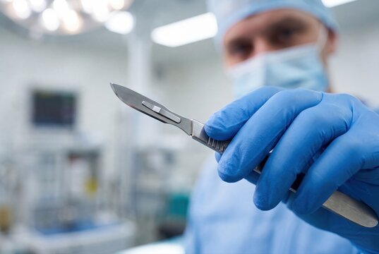 Surgeon holding surgical scalpel blade medical procedure healthcare