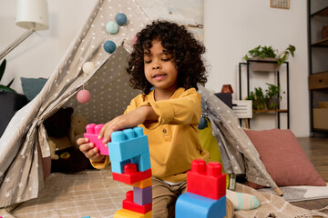 Happy african american boy enjoys creative playtime in a cozy apartment © LIGHTFIELD STUDIOS
