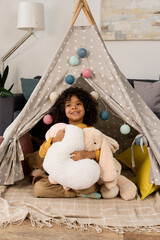 Happy african american boy enjoys playful moments in cozy home setting © LIGHTFIELD STUDIOS