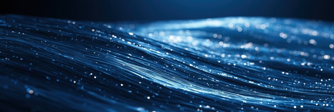 Abstract blue wave of light fibers with glowing particles, representing data flow and technology
