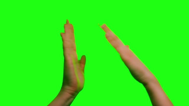 Close-up of applauding hands on green screen background. Clapping gesture isolated on chroma key for editing and compositing. High quality 4k footage